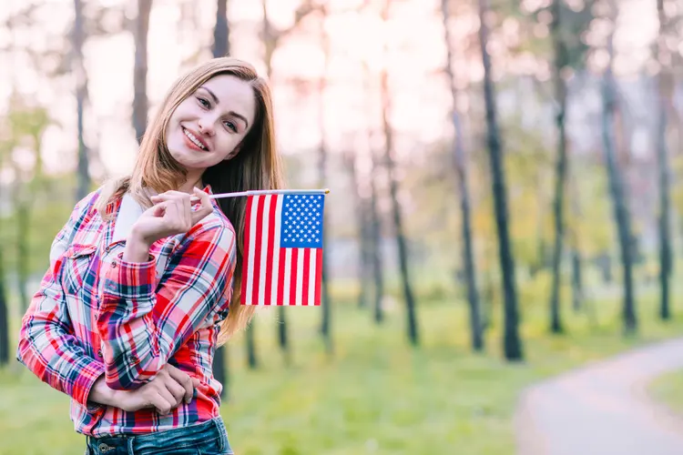 A young women showing American Flag - J1 Visa Requirements